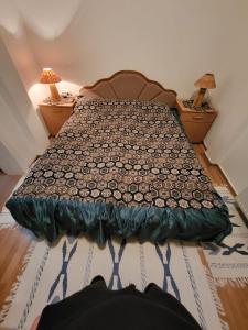 ein Bett in einem Schlafzimmer mit zwei Nachttischen und zwei Lampen in der Unterkunft Apartman VM in Bjelašnica