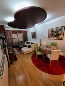 ein Wohnzimmer mit einem Tisch und einem Sofa in der Unterkunft Apartman VM in Bjelašnica