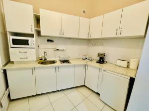 a small kitchen with white cabinets and a sink at Apartament 2 camere Ocnei in Sibiu