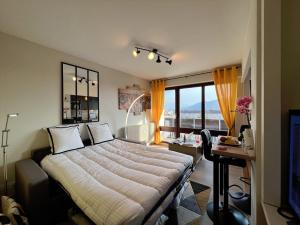 een slaapkamer met een bed, een bureau en een raam bij Empire New York Signature in Annemasse