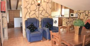 a living room with a table and chairs and a kitchen at Casa el angel in Castril