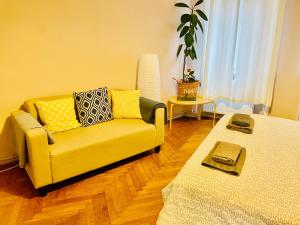 a living room with a yellow couch and a table at Apartament 2 camere Ocnei in Sibiu