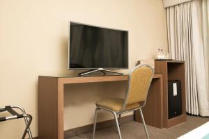 a room with a television on a desk with a chair at HOTEL HANAN in Arequipa