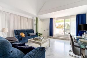 a living room with a blue couch and a table at Sevilla Central Suites Apartamentos Puerta Jerez in Seville