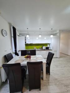 a dining room and kitchen with a table and chairs at Cozy Apartment in Arad