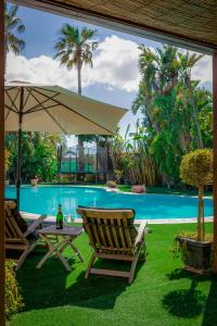 two chairs and an umbrella next to a swimming pool at The Secret Villa in Is-Swieqi