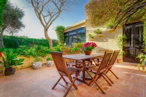 a patio with a wooden table and chairs at The Secret Villa in Is-Swieqi