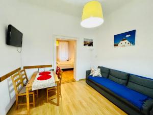 a living room with a blue couch and a table at Apartament 2 camere Ocnei in Sibiu
