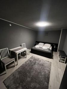 1 dormitorio con 1 cama, mesa y sillas en Casa de vacanță Cheșa en Borsec