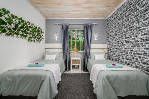 a room with two beds and a brick wall at 302 On Old Sea View Road Chelsea in Port Elizabeth