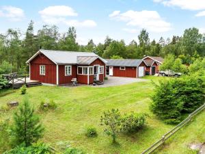 una fila di cabine rosse in un campo con cortile di Holiday home SKÅNES FAGERHULT IV a Skånes Fagerhult