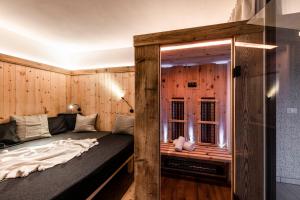 Bett in einem Zimmer mit einer Holzwand in der Unterkunft Bellevue Bruneck - Suites & Lofts in Bruneck