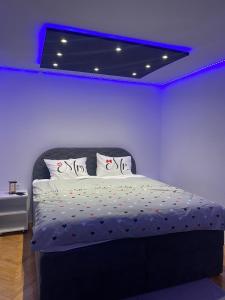 a bedroom with a bed with a blue ceiling at Checkmate in Tešanj