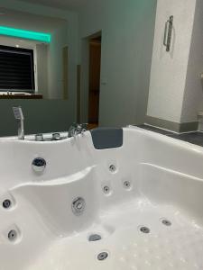 a white bath tub in a bathroom with a mirror at Checkmate in Tešanj