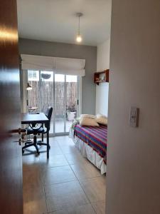 1 dormitorio con cama, escritorio y mesa en Moderno piso de diseño c/ cochera cubierta en Saavedra en Buenos Aires