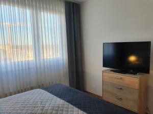 a bedroom with a flat screen tv on a dresser at LANE City Laatzen, nahe Hannover Messe in Hannover +13 photos