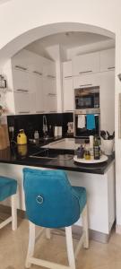 eine Küche mit weißen Schränken und einem blauen Stuhl in der Unterkunft El gouna Ferienwohnung in zentraler Lage in Hurghada