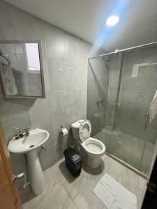 een badkamer met een douche, een toilet en een wastafel bij Hotel Dorado San Luis in San Luis