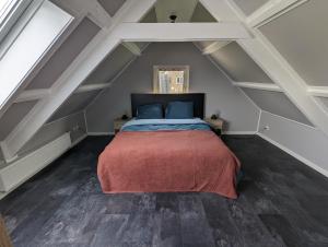 een slaapkamer met een bed op de zolder bij Knus appartement aan bosrand in Hornsterzwaag