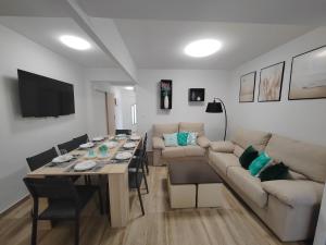a living room with a table and a couch at Casa adosada con pequeño patio in Vilagarcia de Arousa