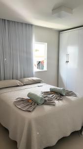 1 dormitorio con 1 cama grande y toallas. en Venha se hospedar no Paraíso de Guarajuba, en Camaçari