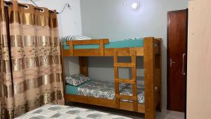 Ce lit superposé se trouve dans un dortoir doté d'un rideau. dans l'établissement Sirius Apart, à Puerto Iguazú