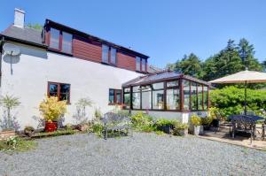 a house with a garden and a patio at Bryncylla Cottage in Llangurig