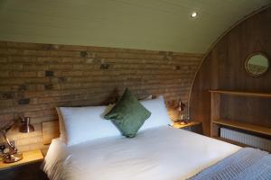 a bedroom with a white bed with a wooden wall at Hare's View in Rhayader