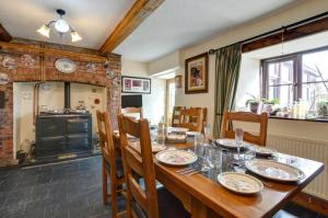 a dining room with a wooden table and chairs at Bryncylla Cottage in Llangurig