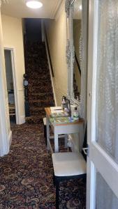 a hallway with a vanity and a mirror and a staircase at Windmill Guest House in Bridlington