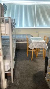 a room with a bunk bed and a table and chairs at Windmill Guest House in Bridlington