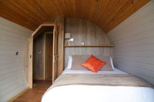 una cama en una habitación con techo de madera en Foxes View, en Rhayader 11 fotos más