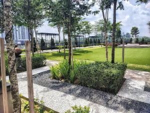 un parque con árboles y plantas y un campo verde en MsHome Suite Equnie Residence @ Taman Equnie Seri Kembangan, en Seri Kembangan