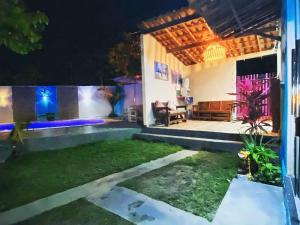 Pousada Canto de Paz في بورتو سيغورو: منزل مع مسبح في الفناء في الليل