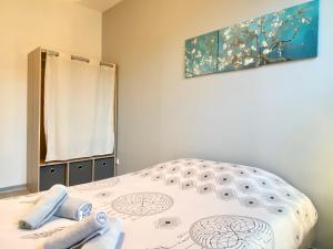 1 dormitorio con 1 cama con una pintura en la pared en Van Gold - Appartement - Centre Ville, en Calais