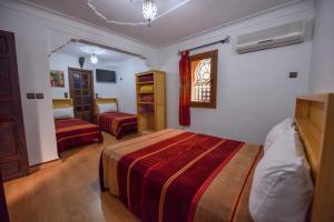 - une chambre avec 2 lits et une fenêtre dans l'établissement Riad Assia, à Marrakech