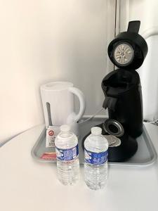 a coffee maker and two bottles of water on a table at Van Gold - Appartement - Centre Ville in Calais