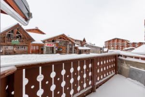 a balcony with snow covered buildings and condos at Val Thorens - Cosy Duplex Silveralp 004 in Val Thorens