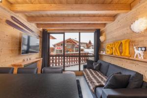 a living room with a couch and a table at Val Thorens - Cosy Duplex Silveralp 004 in Val Thorens