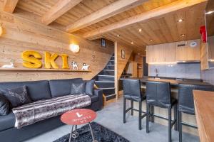 a living room with a couch and a kitchen at Val Thorens - Cosy Duplex Silveralp 004 in Val Thorens