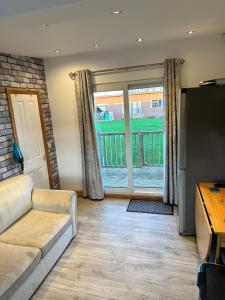 a living room with a couch and a sliding glass door at B3 Rickardos Holiday Lets in Mablethorpe