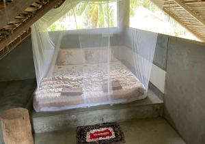 een bed in een netkamer met een raam bij Plastic Bottle House - Dune Towers in Kalpitiya