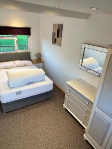 małą sypialnię z łóżkiem i lustrem w obiekcie B3 Rickardos Holiday Lets w mieście Mablethorpe