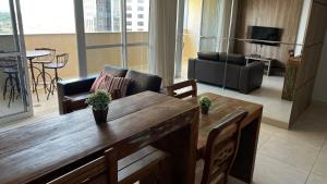 a living room with a wooden table and a couch at Flat Brookfield Towers 2409 in Goiânia