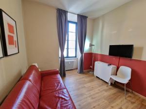 salon z czerwoną kanapą i telewizorem w obiekcie Casa Cavalier w Turynie