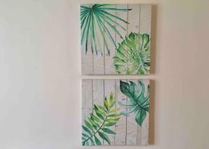 dos cuadros enmarcados de plantas en una pared en Condo , WIFI up to 100mbps , Infinity Pool, en Cebú