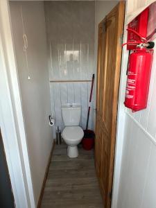 een kleine badkamer met een toilet en een rode brandblusser bij F17 Rickardos Holiday Lets in Mablethorpe