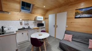 eine Küche und ein Wohnzimmer mit einem Tisch und einem Sofa in der Unterkunft Chalet Sanset in Gèdre