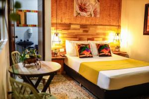 a bedroom with a bed and a table with a chair at Hostal The Garden Lleras 10 in Medellín