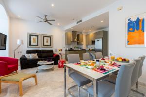 a dining room and living room with a table and chairs at Sevilla Central Suites Apartamentos Puerta Jerez in Seville